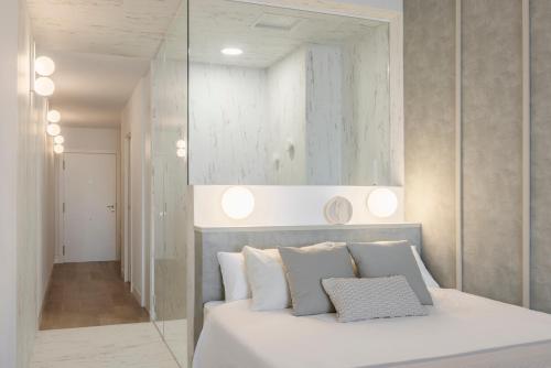 バレンシアにあるDesigner apartment facing the seaの白いベッドと鏡のある寝室