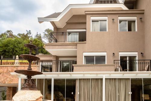 a building with a fountain in front of it at Champet Boutique Hotel in Campos do Jordão