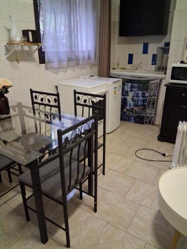 a kitchen with a table and two chairs and a stove at Studio plage in Santa-Maria-di-Lota