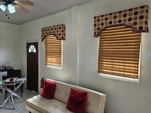 a living room with two windows and a couch at Serene Blue Villa Hide Away in Non-Pariel