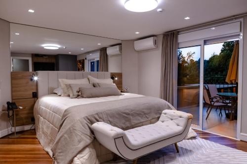a bedroom with a large bed and a chair at Champet Boutique Hotel in Campos do Jordão