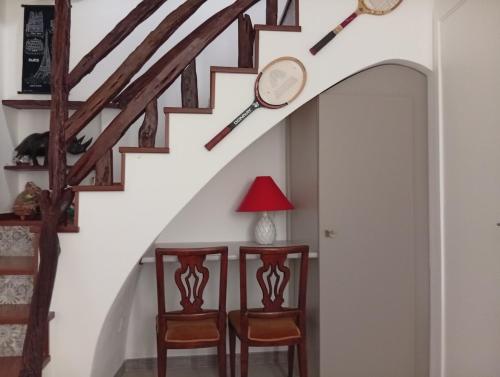 a hallway with stairs with chairs and a lamp at Diongard House in San Vito