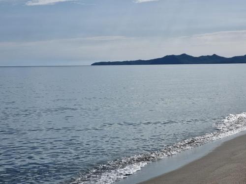 a beach with the ocean and mountains in the background at Diongard House in San Vito