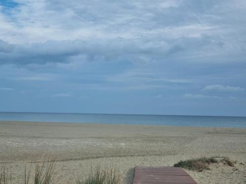 a sandy beach with a cloudy sky and the ocean at Diongard House in San Vito