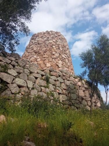 a stone wall with a tower on top of it at Diongard House in San Vito