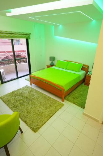a bedroom with a green bed and a green rug at Hotel and Restaurant Shallalat Anjar in ‘Anjar