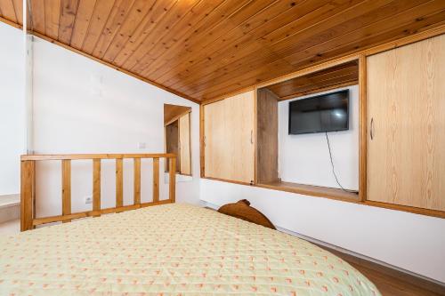 a bedroom with a bed and a tv on a wall at Casa da Muralha in Beja