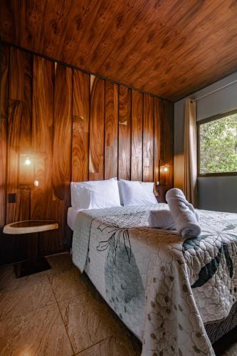 a bedroom with a bed with a wooden wall at Finca Murillo in Monteverde Costa Rica