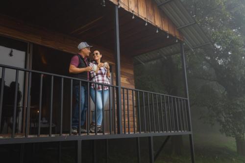 a man and woman standing on a balcony of a house at Finca Murillo in Monteverde Costa Rica