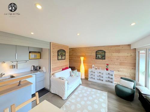 une cuisine et un salon avec un canapé et une table dans l'établissement Cocon renové - Centre station - Rez de jardin, à Huez