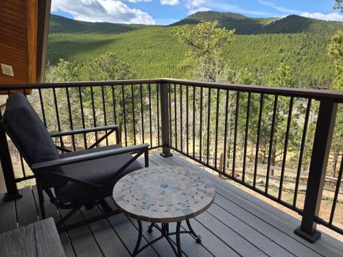 a chair and a table on a porch with a view at Moose Manor in Golden