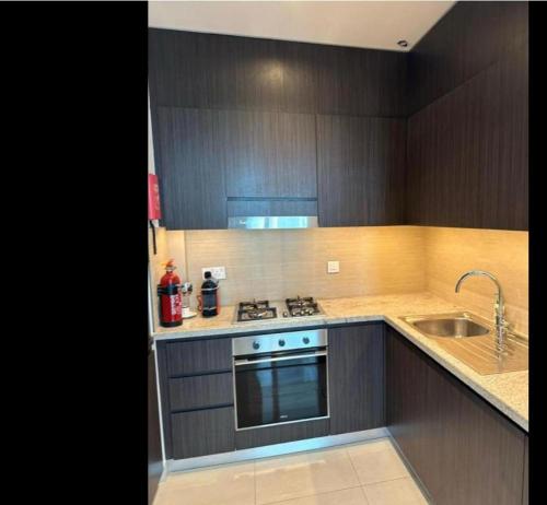 a kitchen with a sink and a stove top oven at Downtown Al Bahar Apartments in Dubai
