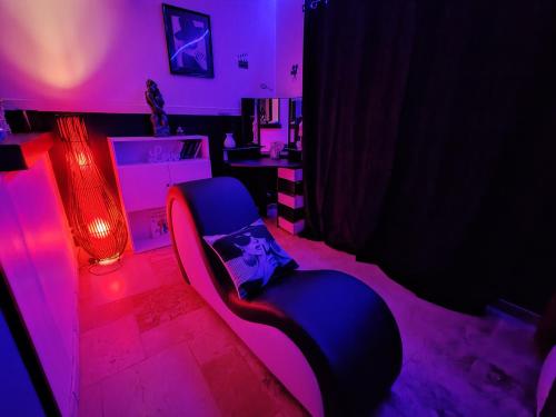 un salon avec une chaise bleue et des lumières violettes dans l'établissement Romance à l' affiche, à Valence