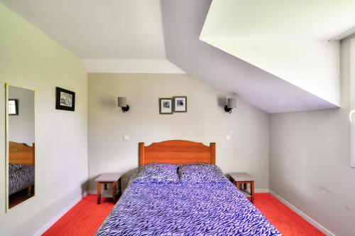 une chambre avec un lit avec une couette violette dans l'établissement La résidence du Lac - maeva Home - Appartement 2 pièces 5 personnes - Sélection MAE-2201, à Monflanquin