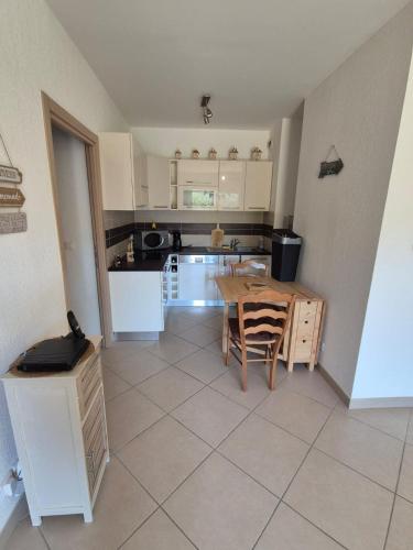 une cuisine avec une table et des chaises dans une pièce dans l'établissement 2 pièces proche mer et commerces, à La Celle-sous-Gouzon