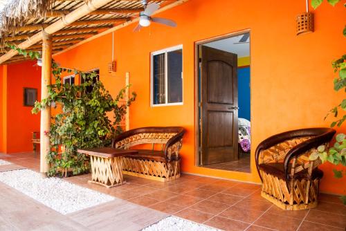 an orange house with two wicker chairs and a door at Casa Juarez B&B in La Paz