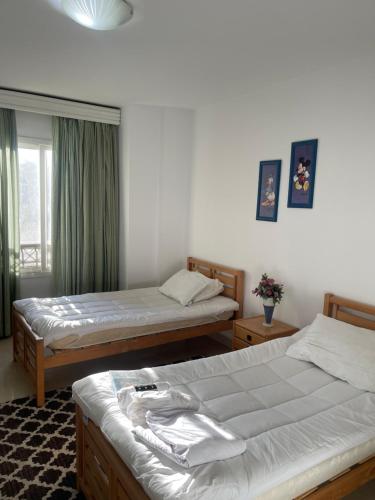 a bedroom with two beds and a window at Adam Madinaty hotel in Madinaty