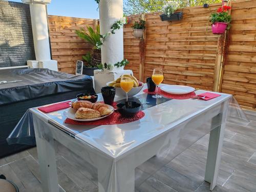 Una mesa con un plato de comida y dos vasos de jugo de naranja. en Romance à l' affiche, en Valence-dʼAgen