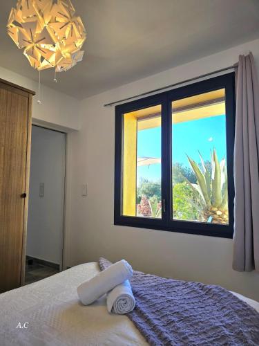 - une chambre avec un lit et une fenêtre avec un cactus dans l'établissement L'echapée Bleue - cosy refait a neuf, avec terrasse et vue jardin, tout se fait à pied - BY AURAconciergerie, à Bandol