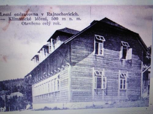 an old picture of a wooden house with a sign at Chata Pod Kapličkou in Rajnochovice