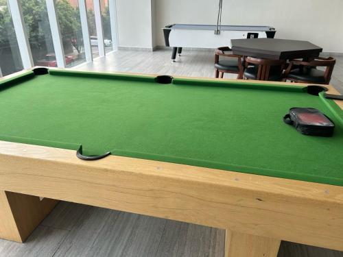 a green pool table with a purse on top of it at Centro Banamex Hipódromo de las Américas Toreo in Mexico City