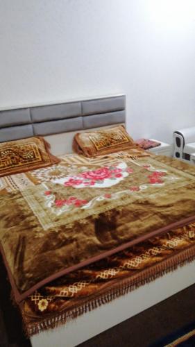 a bed with a blanket and pillows on it at 4 Season Hotel and suites Malam Jabba in Malam Jabba