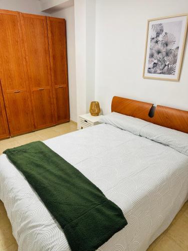 a bedroom with a bed with a green blanket on it at Esparta Home ! in Córdoba