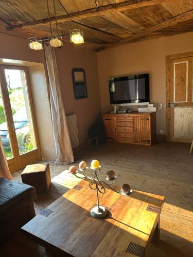 un salon avec une table et une télévision dans l'établissement Relais diligence famille, à Audelange