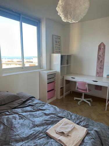 une chambre avec un lit, un bureau et une fenêtre dans l'établissement Cocon Azur avec vue panoramique sur mer - 3 chambres, à Nice