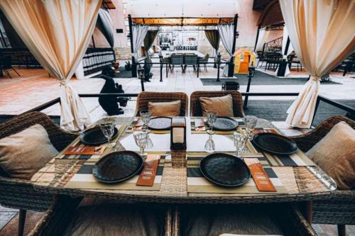 a table with plates and glasses on top at SAMAL Hotel in Aksay