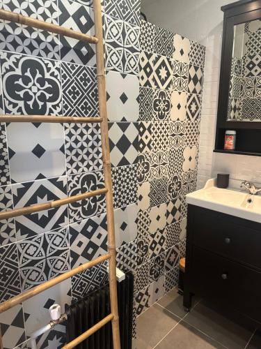 La salle de bains est revêtue de carrelage noir et blanc. dans l'établissement Cocon Azur avec vue panoramique sur mer - 3 chambres, à Nice