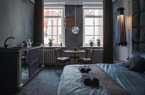 Schlafzimmer mit einem Bett, einem Waschbecken und einem Tisch in der Unterkunft Old Town Hideaway in Vilnius