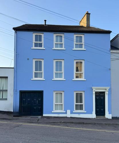 a blue house with two garage doors on a street at The Abbey Yard Townhouse in Newry
