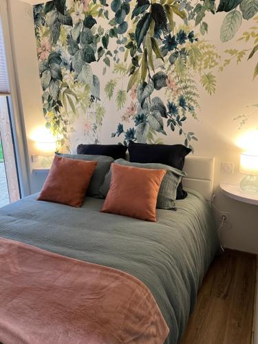 1 dormitorio con 1 cama con pared de flores en Les Villas du Ried, en Daubensand