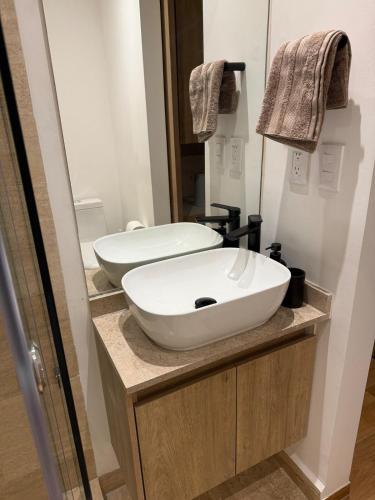 a bathroom with a white sink and a mirror at Comfortable apartment in Reforma, downtown CDMX in Mexico City