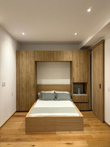 a large bed in a bedroom with wooden walls at Comfortable apartment in Reforma, downtown CDMX in Mexico City