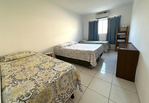 a hotel room with two beds and a window at Fique próximo ao shopping e à Orla in Petrolina