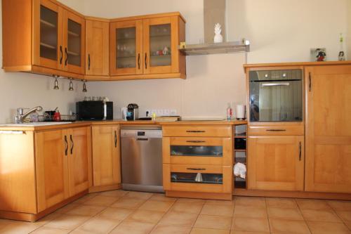 une cuisine avec des armoires en bois et des appareils en acier inoxydable dans l'établissement Villa Chris t'AL Cargèse, à Cargèse