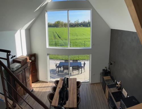 Una habitación con una mesa y una ventana grande. en Les Villas du Ried, en Daubensand