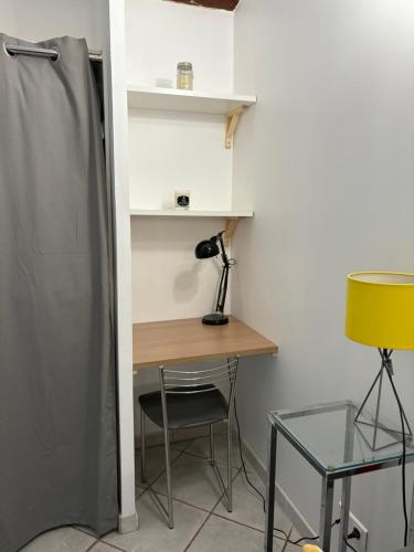 une pièce avec un bureau et une table avec une lampe dans l'établissement Studio tout confort, à La Crau