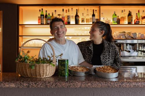 a man and a woman sitting at a counter with food at Hotel La Gioiosa in Finale Ligure