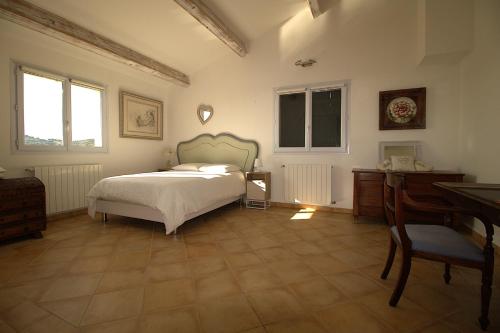 une chambre avec un lit, un bureau et des fenêtres dans l'établissement Villa Chris t'AL Cargèse, à Cargèse