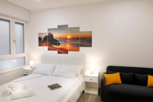 a white bedroom with a bed and a couch at La Vega Comfort Stay in Cagliari