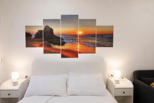 a sunset over the ocean canvas wall art at La Vega Comfort Stay in Cagliari