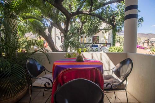 a table and chairs in a balcony with a tree at Hotel Casa Blanca in Ajijic
