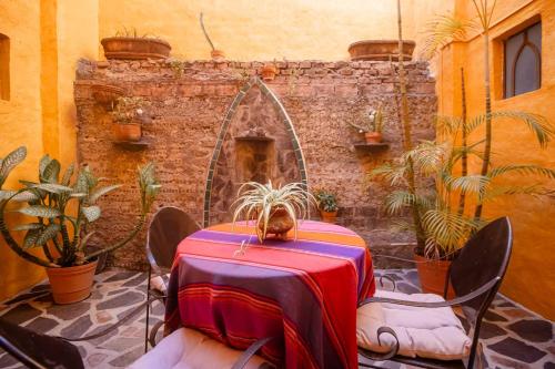 a table in a room with plants and a stone wall at Hotel Casa Blanca in Ajijic