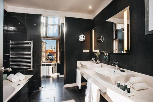 a bathroom with two sinks and a large mirror at Grand Palace Brno - Czech Leading Hotels in Brno