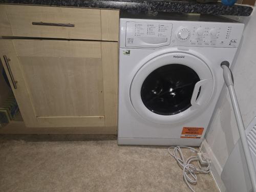 a white washing machine in a kitchen next to a cabinet at Private Room in Hythe