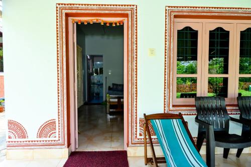 a mirror on a wall next to a table and chairs at Prakruthi Home Stay in Sollebail