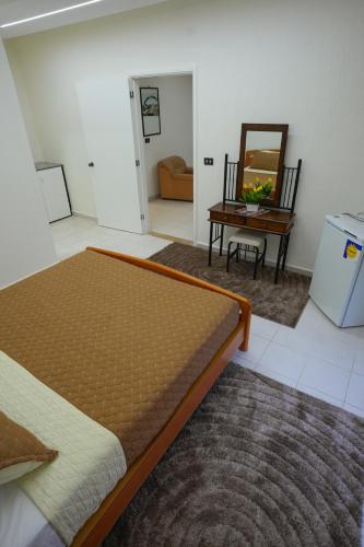 a bedroom with a bed and a table and a mirror at Hotel and Restaurant Shallalat Anjar in ‘Anjar